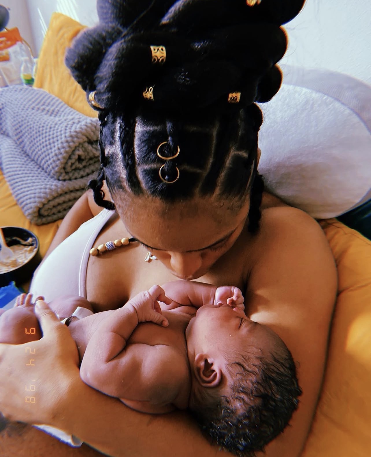 Mother looking down at her newborn resting against her chest while feeding